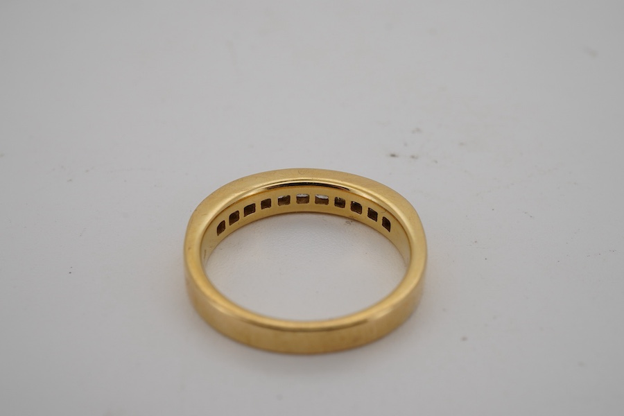 A diamond half hoop ring, channel-set to the front with princess-cut diamonds totalling approximately 0.60 carats, mounted in 18ct gold, size L, British hallmarks, gross weight approximately 4 grams